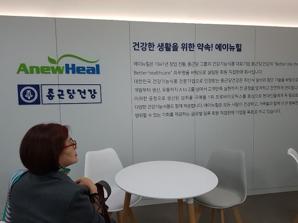▲ 에이뉴힐 서울 비즈니스 센터 벽면에 설치된 회사 소개를 한 판매원이 유심히 살펴보고 있다.
